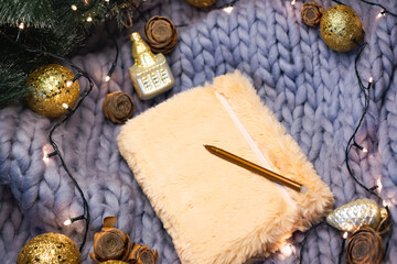 Champagne notebook on gray knitted background with christmas decorations