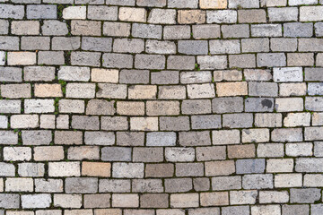 Stone cobble pattern on a street or pavement, grey granite material texture