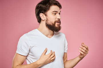 man in white t-shirt gesturing with his hands emotions fun pink background