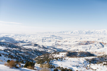 Fototapeta na wymiar Crazy winter panorama of the Tien Shan mountains in Uzbekistan in Beldersay ski resort on a clear winter day