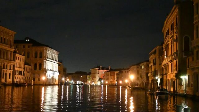 Venice, Italy - November 2020 - The evening lights come on between the palaces and bridges of the Grand Canal
