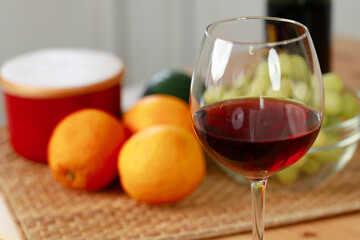 Glass of red wine and oranges on kitchen counter