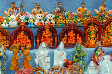 A collection of colorful traditional earthen sculptures and goddess Durga idols.