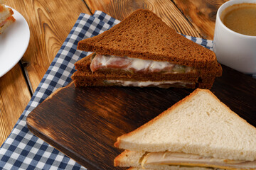 Assortment of toasted triangle sandwiches on wooden board