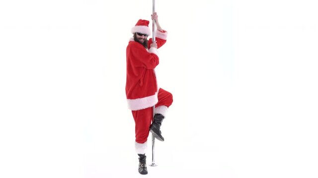 Santa Claus is dancing and stripping on pole, striptease. Lustful arabic young Santa pole dancer with black beard dances on white background