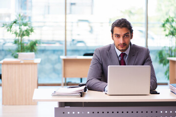Fototapeta premium Young male employee working in the office