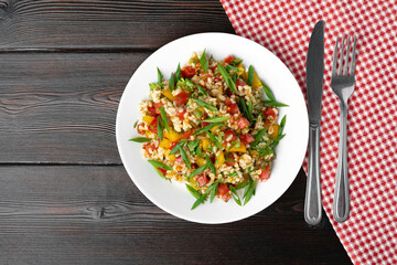 Georgian Tabbouleh salad with bulgur and vegetables on black wooden table