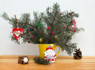 christmas composition of fir branches and feastday decor in a yellow cup