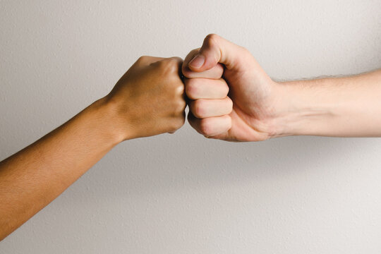 woman and man bumping fists on a white background.