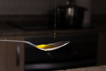 putting virgin olive oil from Spanish olives in a spoon for cooking or dressing. Healthy food...