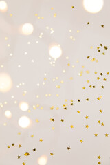 Festive gold background. Shining stars confetti and fairy lights on beige and Set Sail Champagne...