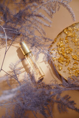 Travel size perfume bottle on warm pastel and golden table