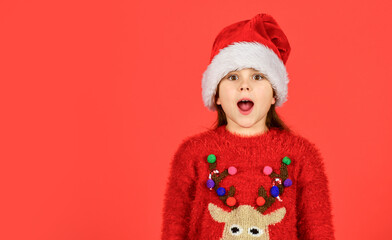 Emotional face expression. Happy childhood. Counting days till christmas. Christmas party. Can not hold back emotions. Christmas holiday invitation. Adorable girl wear santa claus hat red background