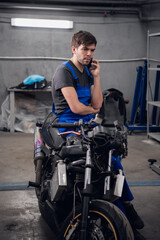A worker talking to a client on the phone about a motorcycle