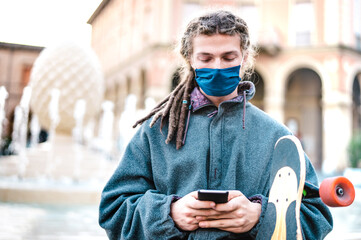 Unhappy guy with protective mask using tracking app on mobile smartphone - Young worried millenial...