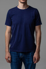 Young male in blank navy t-shirt, front view. Design men t shirt template and mock-up for branding...