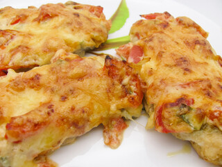 Chicken fillet baked in the oven under a cheese coat with tomatoes, sweet pepper, mayonnaise and mustard.