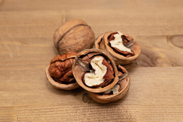 Tasty brown walnuts on wood background. Opened and not disclosed