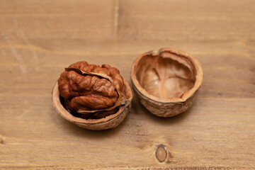 Tasty brown walnuts on wood background. Opened and not disclosed