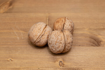 Tasty brown walnuts on wood background. Opened and not disclosed