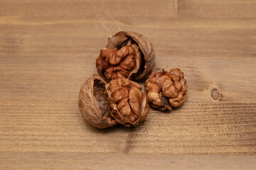 Tasty brown walnuts on wood background. Opened and not disclosed