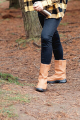 woman in yellow  boots walking in autumn forest