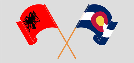 Crossed and waving flags of Albania and The State of Colorado