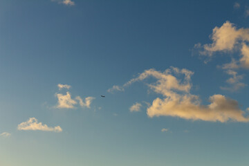 Striking fluffy clouds in the blue sky. Background for designers. Plane in the sky
