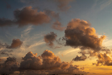 Striking fluffy clouds in the blue sky. Background for designers. Cumulus in the sunset