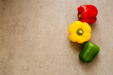 Fresh yellow, green and red pepper on wooden background, flat lay