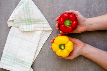 Fresh yellow and red peper on woman's palms, flat lay