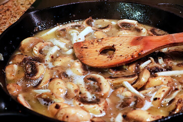 Closeup of a pan of mushroom cream sauce cooking