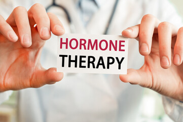 Doctor holding a card with text HORMONE THERAPY, medical concept