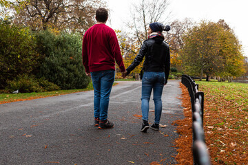 Attractive young couple walking together around Saint James park during the autumn season.