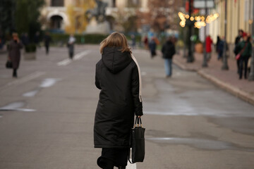 a woman walking down the street from the back