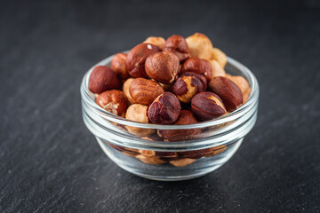 fresh natural hazelnuts on a dark stone background