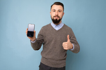 Closeup photo of amazing guy holding modern telephone hands casual outfit isolated on bright blue background