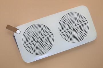 Modern bluetooth speaker on pastel pink background.
