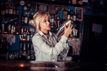 Girl bartender concocts a cocktail at the saloon