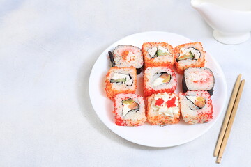 Fresh sushi rolls with sauce on a light background, traditional japanese cuisine, place for text, top view, banner for shop advertisement or invitation,