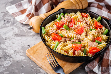 delicious traditional Italian pasta with tuna on a dark rustic stone background