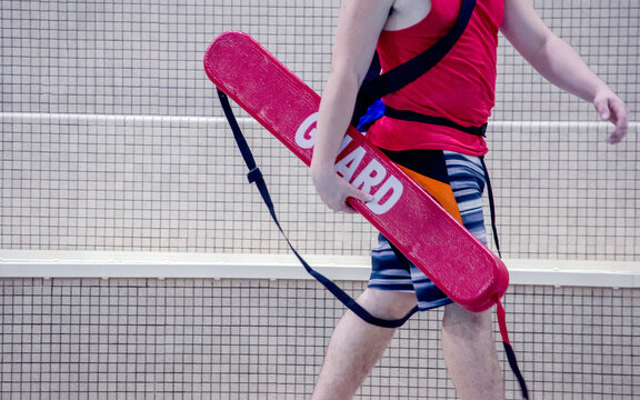 An Indoor Life Guard Walks Alongside The Pool, Watching For Anyone In Distress