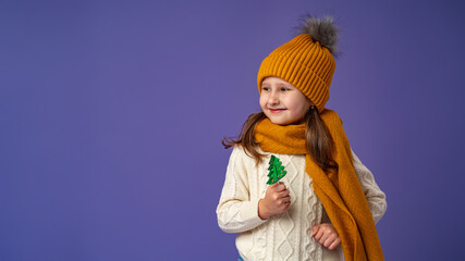 little girl in hat, holding Lollipop, stand happily smiling on purple background