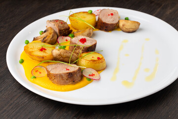 grilled beef steak with potatoes, red caviar and green onions. mustard sauce on a white plate