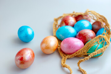 multi colored eggs in a knitted bag