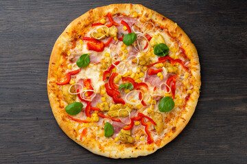Italian pizza with melted mozzarella cheese, olives and sausage garnished with fresh vegetables and...