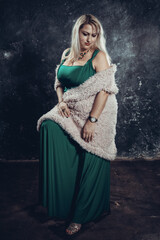 Attractive plump woman in green dress studio portrait.