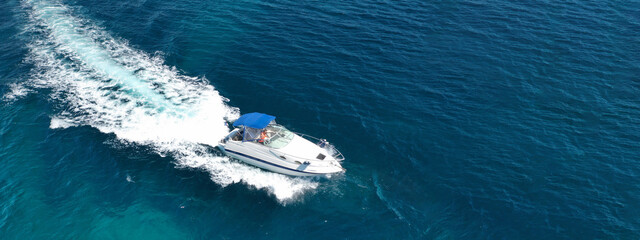 Aerial drone ultra wide panoramic photo of luxury yacht cruising in high speed in open ocean deep blue sea