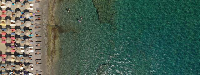 Aerial drone ultra wide top down photo of organised sandy paradise beach with sunbeds and umbrellas