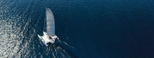 Aerial drone ultra wide photo of luxury Catamaran sailboat cruising in low speed in Mediterranean...